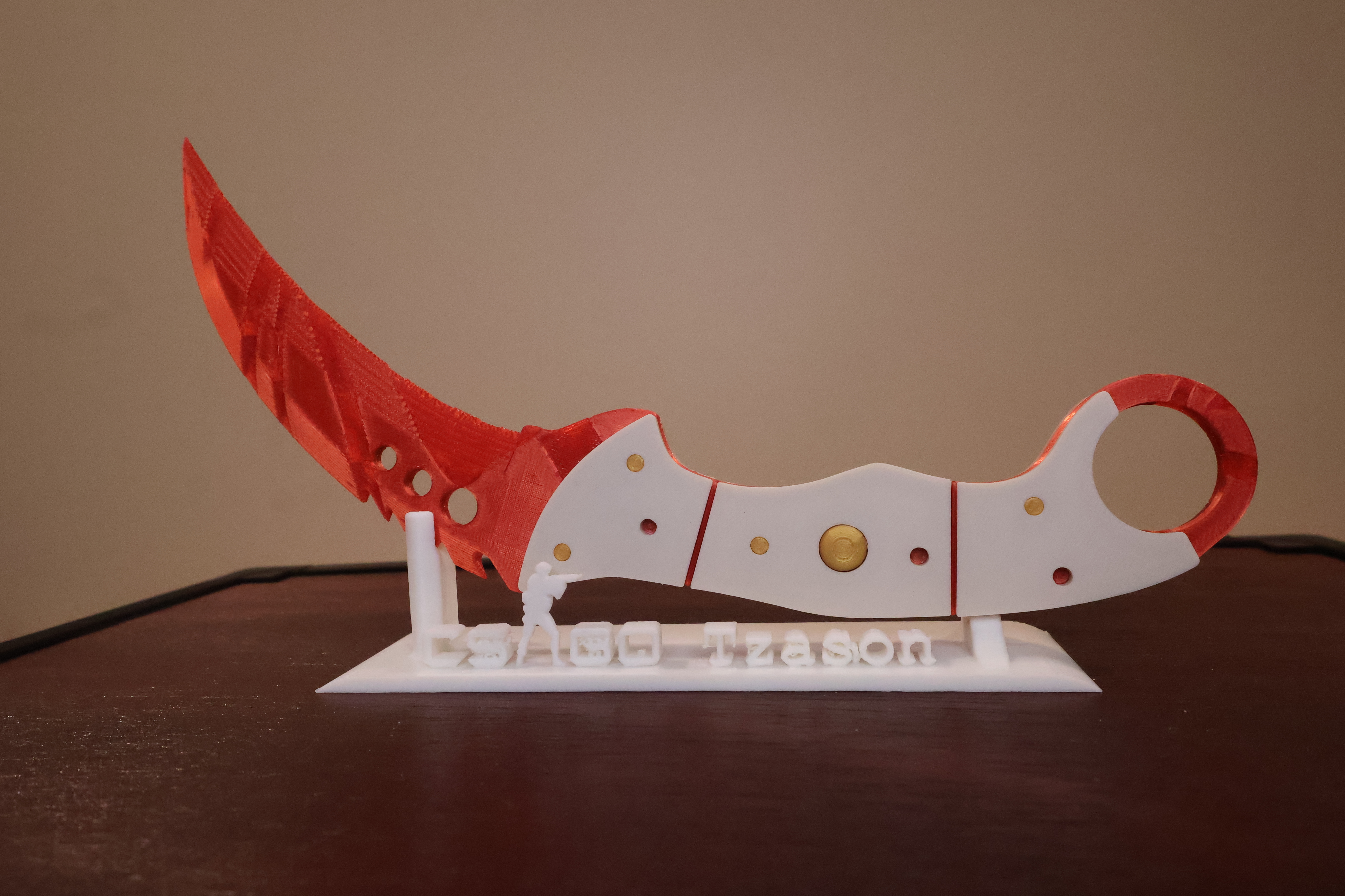 3D printed CS2 Talon knife replica in Slaughter skin — held by maker against a dark workshop background