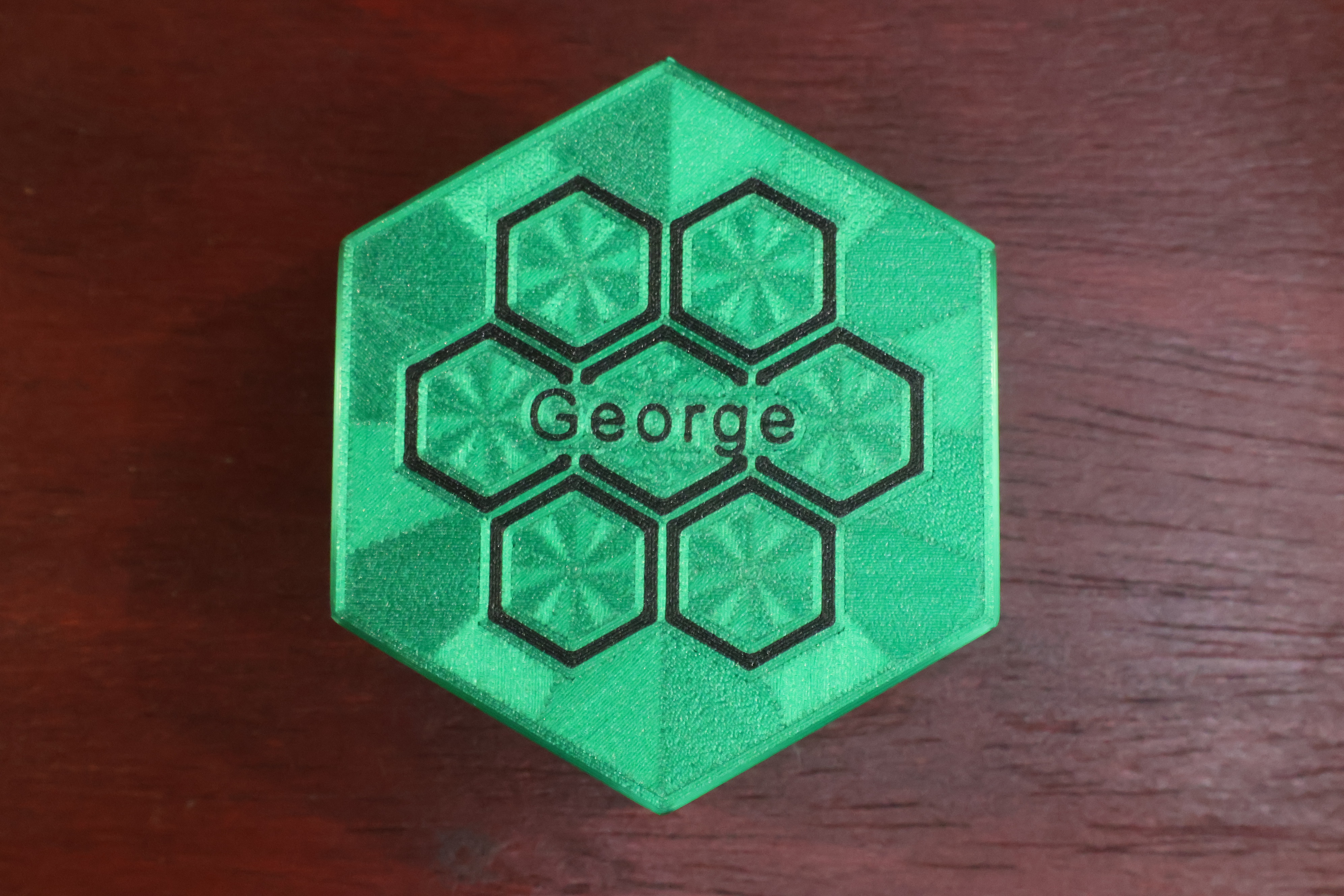 Top-down view of a hand-finished player box lid engraved with custom family names